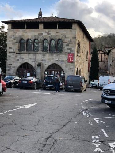 a parking lot with cars parked in front of a building at Chez Sophie et Gege. Maison de ville, deux chambres, de plain-pied in Figeac