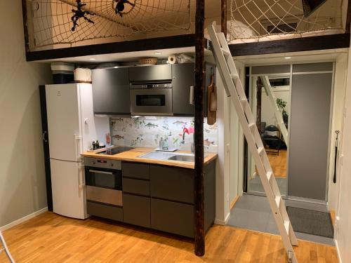 a kitchen with a loft bed with a sink and a refrigerator at Fullt utrustat Minihus på landet in Västerhaninge