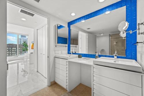 uma casa de banho com 2 lavatórios e uma parede azul em 41st Floor Icon Brickell Corner 2 bed/2bath with Bay and CityView • 5 star SPA em Miami