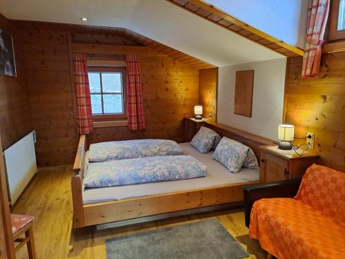 ein Schlafzimmer mit einem Bett in einer Holzhütte in der Unterkunft Wachtlerhof in Matrei in Osttirol