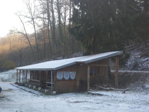 un petit bâtiment en bois avec un toit enneigé dans l'établissement wagons dortoir, 