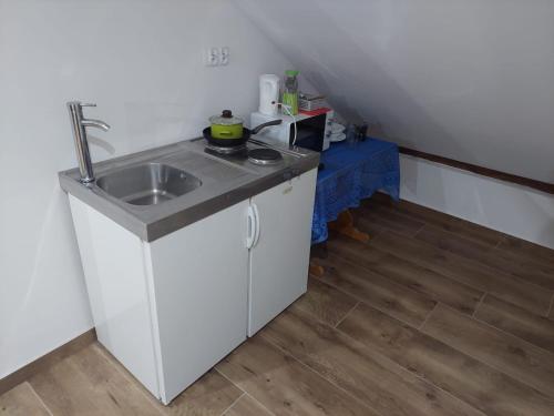 uma pequena cozinha com um lavatório e uma mesa em Agroturystyka noclegi podlesie em Gorlice
