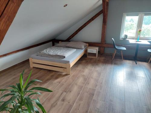 a bedroom with a bed and a chair in a attic at Agroturystyka noclegi podlesie in Gorlice