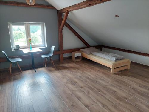 a bedroom with a bed and a desk and a window at Agroturystyka noclegi podlesie in Gorlice
