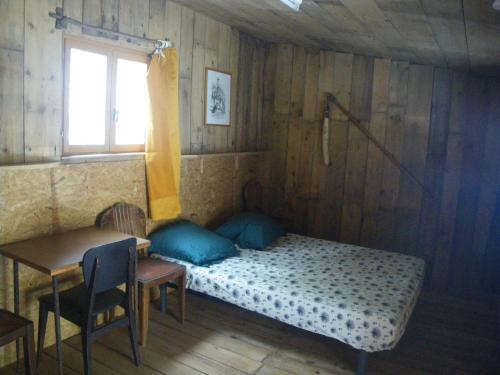 une chambre avec un lit, une table et une fenêtre dans l'établissement wagons dortoir, à Chaudenay