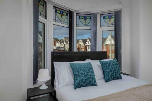 a bedroom with a bed and a window with stained glass at Cozy Apartment 3 - Free Parking & Long Stays in Blackpool