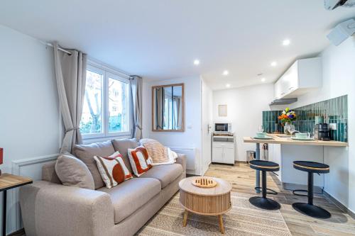 un salon avec un canapé et une cuisine dans l'établissement Éden Spa & Cinéma, à Les Essarts-le-Roi