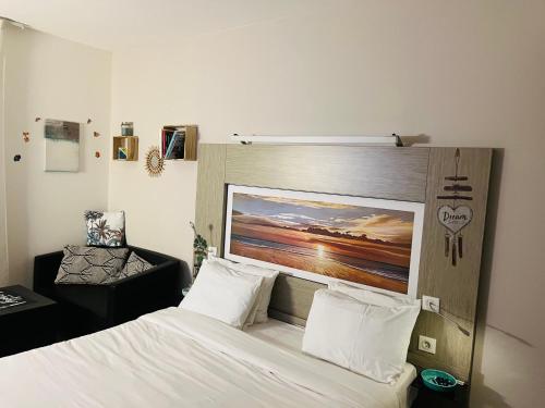 a bedroom with a bed with a painting on the wall at Appart Hôtel 3* dans une résidence de tourisme in Le Mée-sur-Seine