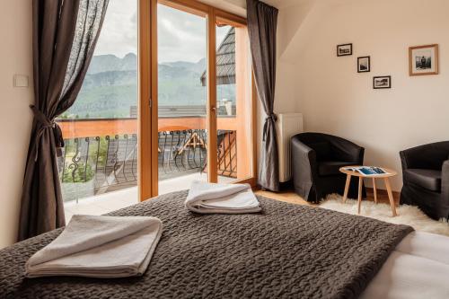 a bedroom with a bed and a large window at Domy Mountain Premium in Kościelisko