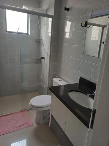 y baño con aseo, lavabo y espejo. en Apartamento aconchegante perto da praia, en Balneário Camboriú