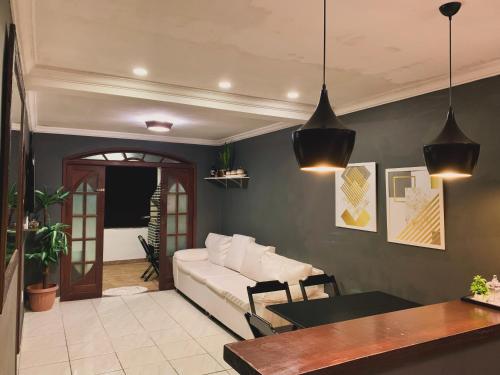 ein Wohnzimmer mit einem weißen Sofa und einem Tisch in der Unterkunft Apartamento Praia do Bonfim in Angra dos Reis