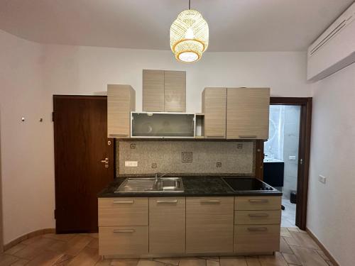 une cuisine avec un évier et un micro-ondes dans l'établissement Capodanna, à deux pas des plages au cœur de la vieille ville, à Menton