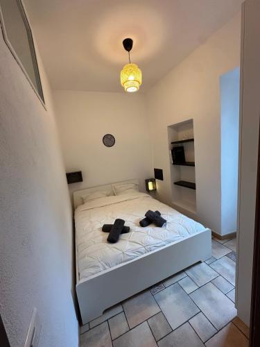 - une chambre dotée d'un lit blanc avec deux chapeaux noirs dans l'établissement Capodanna, à deux pas des plages au cœur de la vieille ville, à Menton