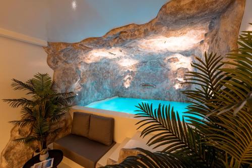 a room with a swimming pool in a rock wall at Ftelia Black Villas in Elia
