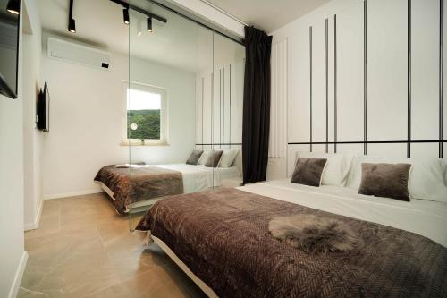 a bedroom with two beds and a window at AMBER in Rabac