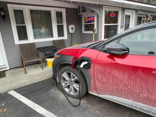 a red car is parked in a parking lot at Sleep Woodstock Motel in Woodstock