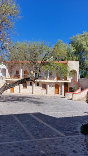 a stone building with a tree in front of it at Hotel Casa Caro in Bernal