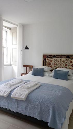 1 dormitorio con 2 camas grandes y almohadas azules en Apartamento da Torre, en Guarda