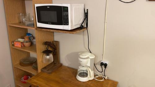 a microwave sitting on a shelf next to a coffee maker at Departamento en el centro Tafi del Valle in Tafí del Valle
