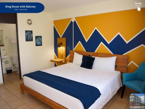a bedroom with a bed with a blue and yellow wall at West Coast Inn's in Boqueron