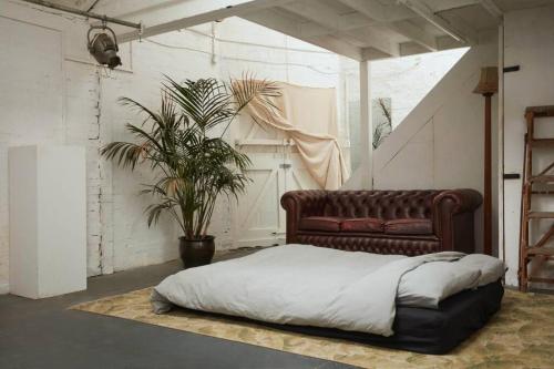 a bedroom with a bed and a potted plant at Warehouse flat East London in London