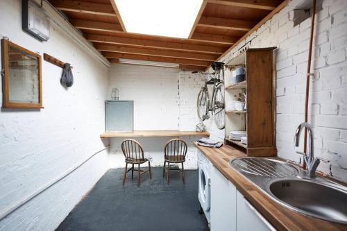a kitchen with a counter with two chairs and a sink at Warehouse flat East London in London