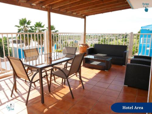 a patio with a table and chairs and a couch at West Coast Inn's in Boqueron