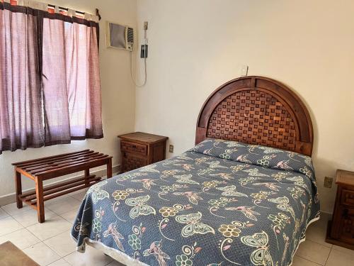 a bedroom with a large bed and a wooden headboard at Hotel Posada Andaluz in Xochitepec