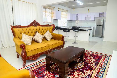- un salon avec un canapé jaune et une table dans l'établissement Bali Luxury Apartments Diani, à Ukunda