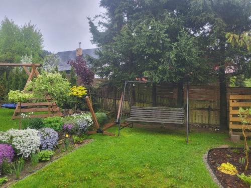 een tuin met een bankje in het park en wat bloemen bij Cichy Zakątek in Uście Gorlickie