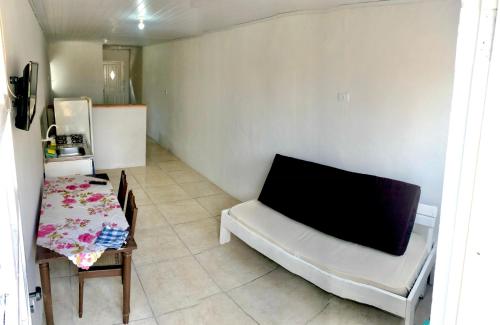 a room with a table and a couch and a kitchen at Kitnet a 150m da praia in Rio Grande