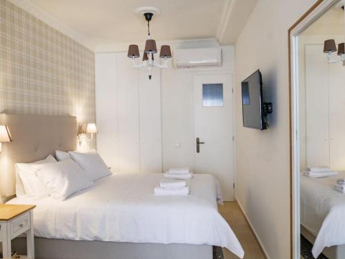 - une chambre blanche avec un lit et un miroir dans l'établissement Filigran I - Stylish Apartment with Free parking, à Ioannina
