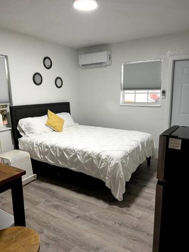 Dormitorio con cama con almohada amarilla en Nice and Cozy guest house en Miami