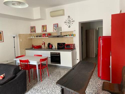 eine Küche mit einem Tisch und einem roten Kühlschrank in der Unterkunft I Marici in Pavia