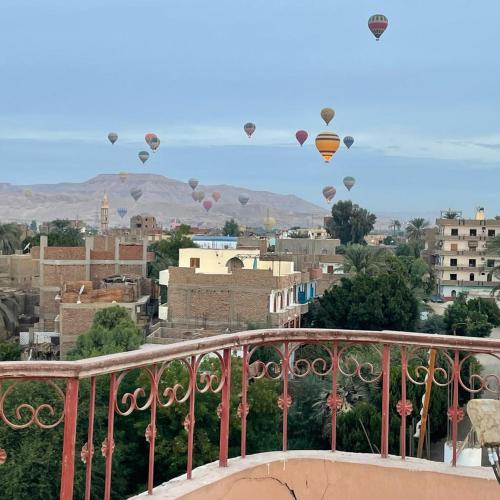a bunch of hot air balloons flying over a city at Moonlight Home in Luxor