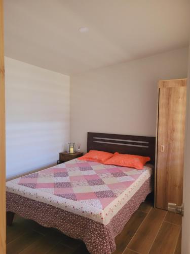 a bedroom with a bed with a quilt on it at Arriendo diario Futrono in Futrono