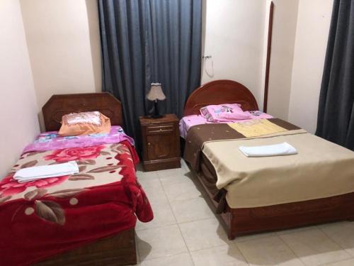 a room with two beds and a nightstand and sidx sidx sidx sidx at Moonlight Home in Luxor