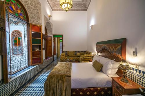 a bedroom with a bed and a living room at La Perle de La Medina in Fez
