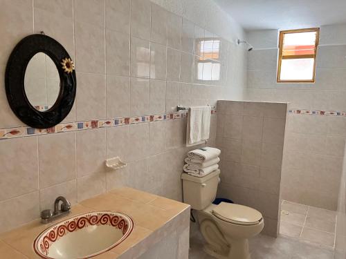a bathroom with a toilet and a sink and a mirror at Hotel Posada Andaluz in Xochitepec