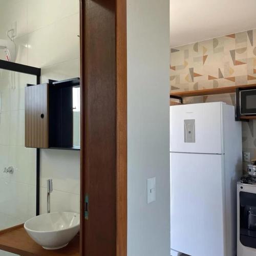 a kitchen with a white refrigerator and a sink at ponta do papagaio in Palhoça