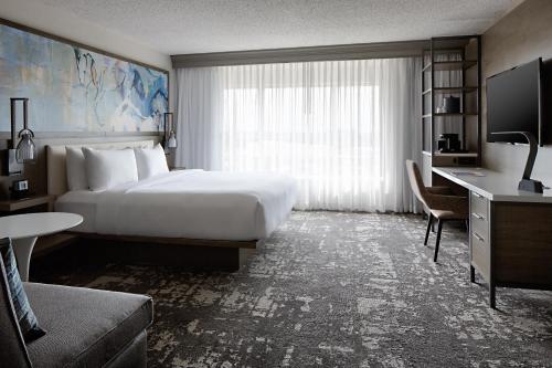 a hotel room with a large bed and a desk at Marriott Dallas Las Colinas in Irving