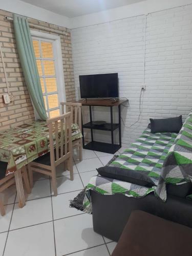 Zimmer mit einem Sofa, einem Stuhl und einem Tisch in der Unterkunft Canto Rei Cabanas Rosa Sul in Imbituba