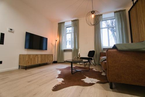 ein Wohnzimmer mit einem TV und einem Tisch in der Unterkunft Goethe-Suites: Premium 4 Person Worms city centre Appartment in Worms