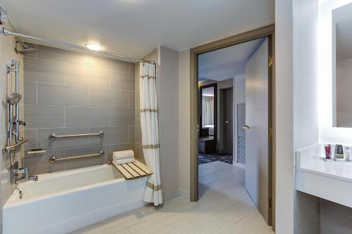 a bathroom with a tub and a sink at Marriott Dallas Las Colinas in Irving