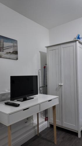 a white desk with a tv and a white cabinet at *Modern 1 bedroom Apt next to centre* in Leeds