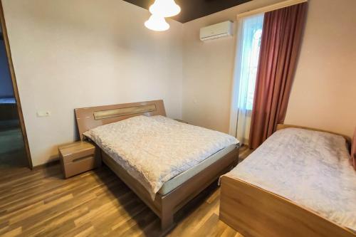 een slaapkamer met 2 bedden en een raam bij Mango's Guesthouse in Koetaisi