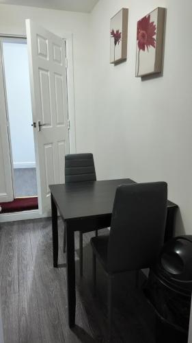 a black table and chairs in a room with a door at *Modern 1 bedroom Apt next to centre* in Leeds