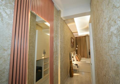 a hallway with a mirror and a bed in a room at Luxury Medea Taksim Hotel in Istanbul
