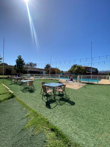 um grupo de mesas de piquenique num campo com piscina em Tierras Del Sol em Quilpué