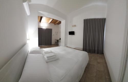 - une chambre avec un grand lit blanc dans l'établissement l'aira ecchia - ospitalità rurale, à Lecce